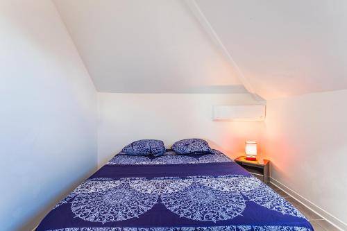 a bed in a small room with a blue comforter at appartement haut standing au grands fonds du moule, 6 pers, très spacieux in Le Moule