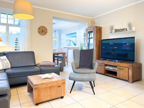 a living room with a couch and a flat screen tv at Ferienhaus Meeresrauschen in Groß Kirr