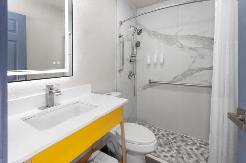 een badkamer met een wastafel, een toilet en een douche bij Days Inn by Wyndham Waukegan in Waukegan