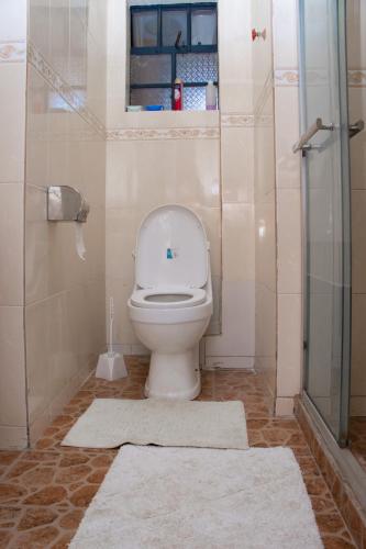 a bathroom with a toilet and a glass shower at Prissy Apartment in Nairobi