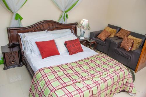 a bedroom with a bed and a couch at Prissy Apartment in Nairobi