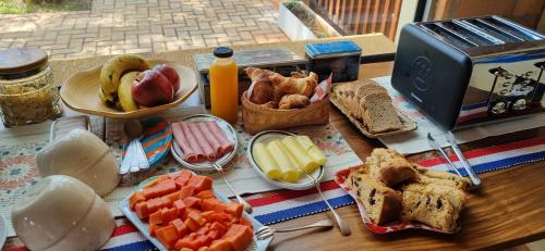 a table topped with sandwiches and fruit and a toaster at San Cosme y Damian Lodge & Spa in San Cosme y Damián