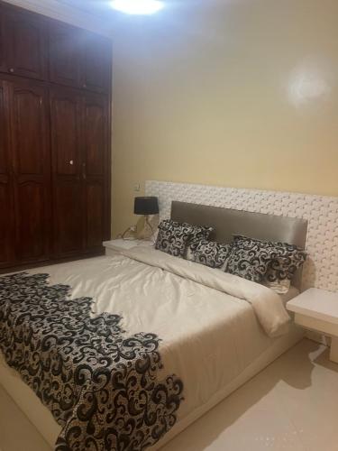 a bedroom with a large bed with black and white pillows at Honey house in Marrakesh