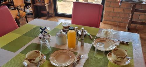 a table with plates and cups and bottles of orange juice at San Cosme y Damian Lodge & Spa in San Cosme y Damián