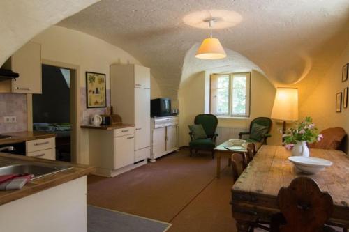 a kitchen and living room with a table and chairs at Gut Ottmanach "Josefhof" in Pischeldorf