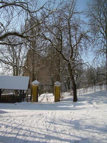 a snow covered park with a fence and trees at Gut Ottmanach "Josefhof" in Pischeldorf