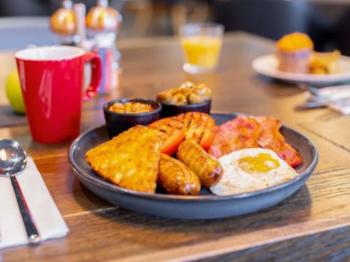 een bord met eten met eieren, aardappelen en toast bij Novotel Leeds Centre in Leeds