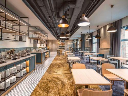 een restaurant met tafels en stoelen en een cafetaria bij Mercure Wrocław Centrum in Wrocław