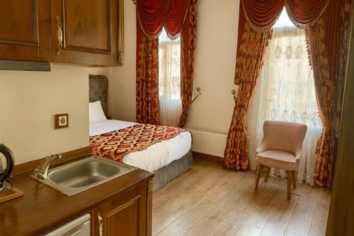 a kitchen with a sink and a bed in a room at BeyPort Hotel Istanbul in Istanbul