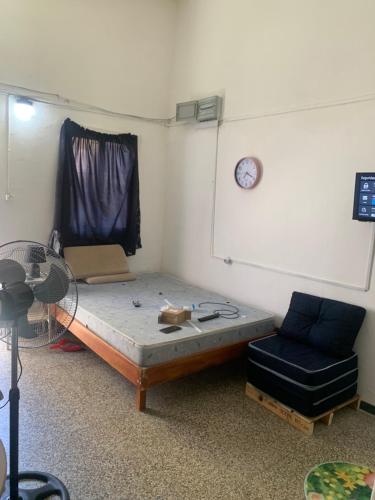 een kamer met een bed, een stoel en een klok bij Los primos in Piriápolis