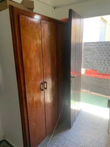 een grote houten kast in een kamer met een raam bij Los primos in Piriápolis