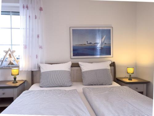 a bedroom with two beds and a picture on the wall at Inselperle in Zingst