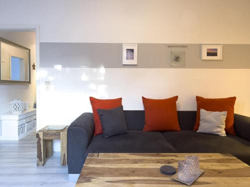 a living room with a couch with orange and blue pillows at Inselperle in Zingst