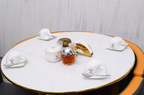 un tavolo bianco con piatti e cucchiai sopra di Mpaata Empire Royal Suites a Hoima