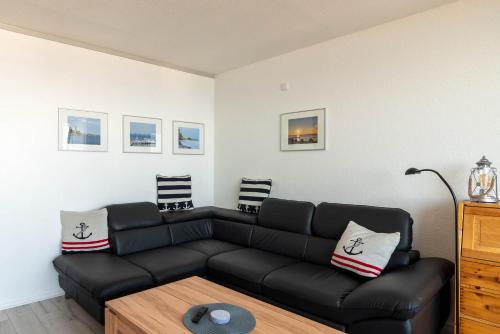 a living room with a black couch and a table at Kiel Water 4 in Schilksee