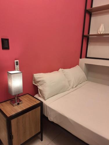 a bedroom with two beds and a table with a lamp at Adhoc Fundidora in Monterrey