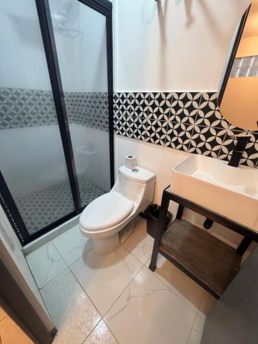 a bathroom with a toilet and a sink at Adhoc Fundidora in Monterrey