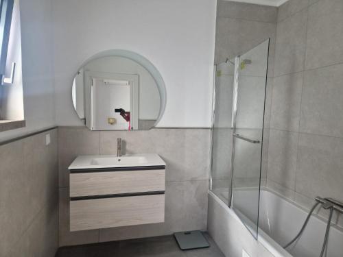 a bathroom with a sink and a shower and a mirror at Tavira Casa with Pool in Tavira