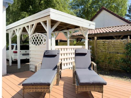 two chairs and a gazebo on a wooden deck at Haus am Strand in Zingst