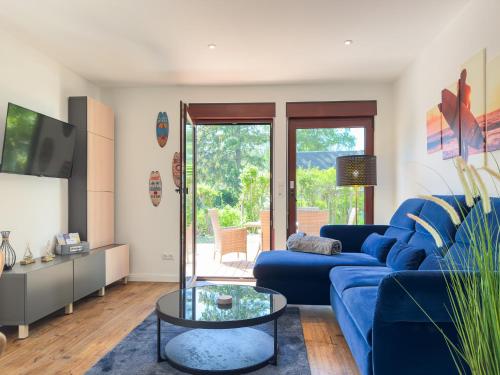 a living room with a blue couch and a table at Haus am Strand in Zingst