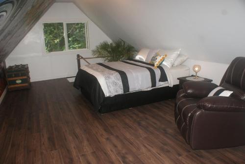 a bedroom with a bed and a couch at Nesting Ravens cottage in Nanaimo