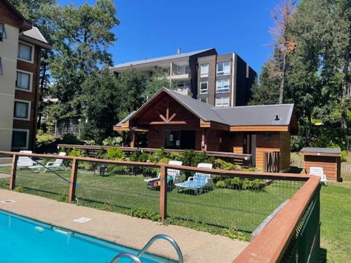 una casa con piscina di fronte a un edificio di Parque del Volcan Pucon a Pucón