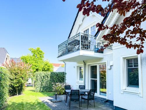 ein weißes Haus mit einem Tisch und Stühlen in der Unterkunft Meerle 3 in Zingst