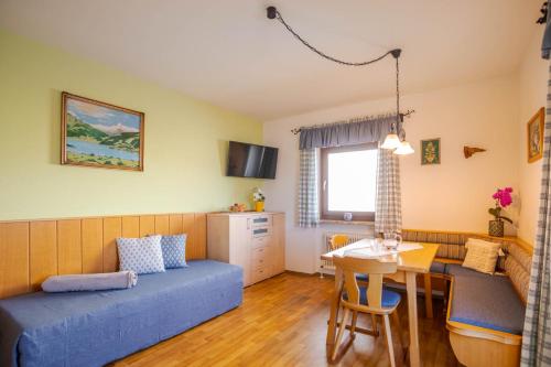 a small room with a bed and a table and a kitchen at Bio Bauernhof Holzegghof in Zell am See in Erlberg