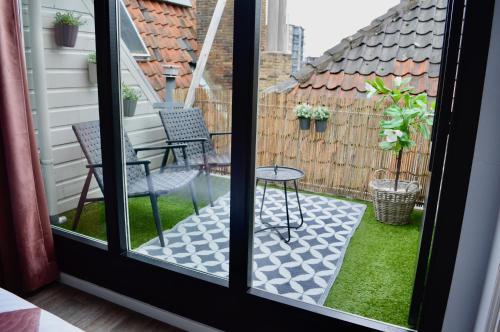 een terras met een tafel en stoelen op een balkon bij Logeren aan de Haven - Appartement Spijkerbrug in Middelburg