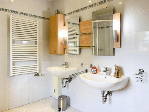 een badkamer met twee wastafels en een spiegel bij Darßwaldradler in Wieck