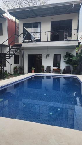 ein großer blauer Swimmingpool vor einem Haus in der Unterkunft Lodge Mar y Sol in Sámara