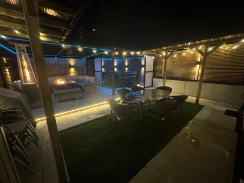 a patio with a table and chairs at night at 5 Bed Town House With Additional Luxury Hot Tub And Within City Centre And Sleeps Up To 11 With Sky And Netflix in Birmingham