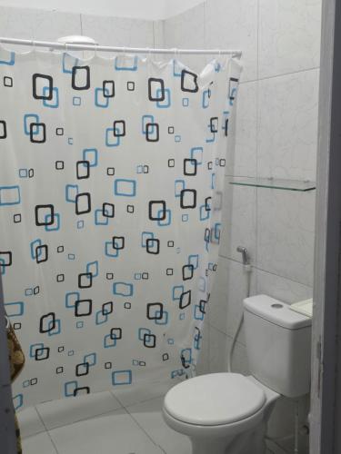 a bathroom with a toilet and a shower curtain at Casa Maúna in Prea