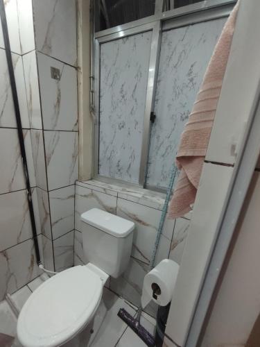ein kleines Badezimmer mit Toilette und Fenster in der Unterkunft Casa na melhor localização de Santa Teresa in Rio de Janeiro