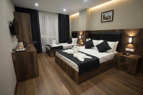a hotel room with two beds and a television at BZN Airport Hotel in Arnavutköy