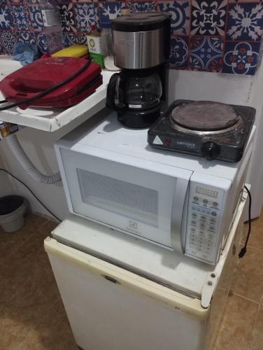 eine Mikrowelle auf einem Kühlschrank in der Unterkunft Casa na melhor localização de Santa Teresa in Rio de Janeiro