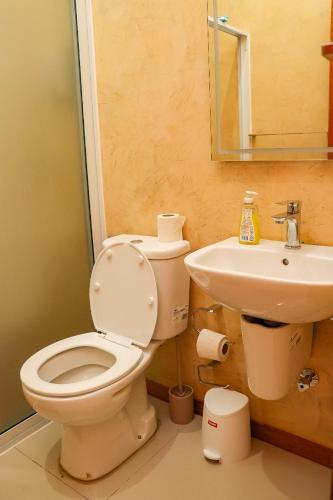 a bathroom with a toilet and a sink at Residencial Chez Flávia in Pombas