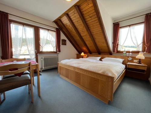 ein Schlafzimmer mit Bett, Schreibtisch und Fenstern in der Unterkunft Hotel Bergfreiheit 7 in Schonach
