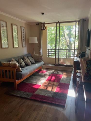 een woonkamer met een bank en een groot raam bij Parque del Volcan Pucon in Pucón