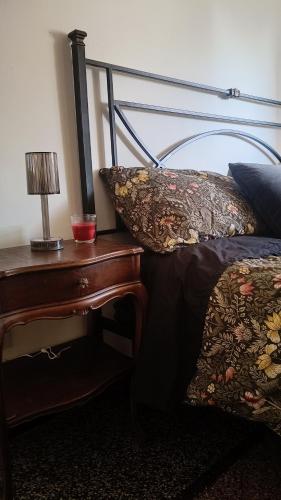 ein Schlafzimmer mit einem Bett und einem Tisch mit einer Lampe in der Unterkunft Centurion's House in Genua