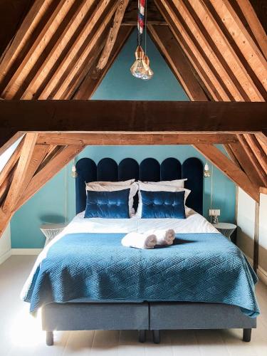 a bedroom with a blue bed with a stuffed animal laying on it at Number 9 holiday apartments in Middelburg