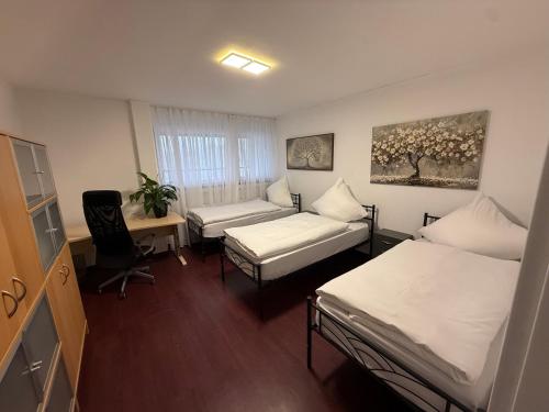 a room with two beds and a couch and a desk at Ferienwohnung-Montagewohnung 4 in Paderborn