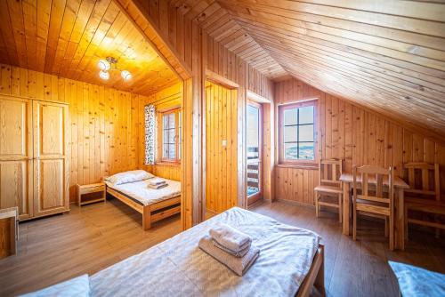 a bedroom with two beds in a wooden room at Osada Golców in Stara Wieś
