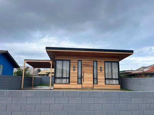 a small house with a roof on top of a wall at Cabana Maciambu casa de praia Palhoça SC in Palhoça