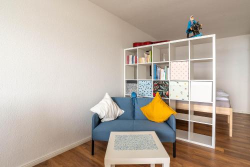 ein Wohnzimmer mit einem blauen Sofa und einem Bücherregal in der Unterkunft Immerschön in Schilksee