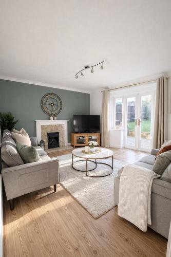 a living room with a couch and a table at Champflower House- Sleeps 7- Driveway Parking, Contractors, Fast Wifi and Smart TV in Milton Keynes