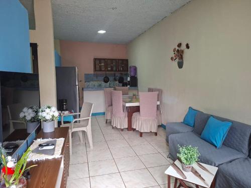 a living room with a blue couch and a table at Casa Albacora in Puerto Baquerizo Moreno