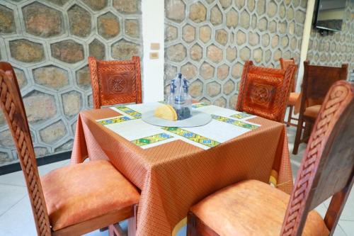 a table with chairs and a table with a plate of food at Kings Land Hotel in Lalībela