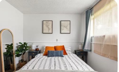 una camera da letto con un letto con cuscini arancioni e blu di Cozy East County Jewel a Portland