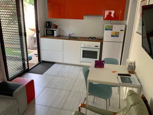 a small kitchen with a table and chairs and a kitchen with at Jetty Rd Granny Flat in Normanville